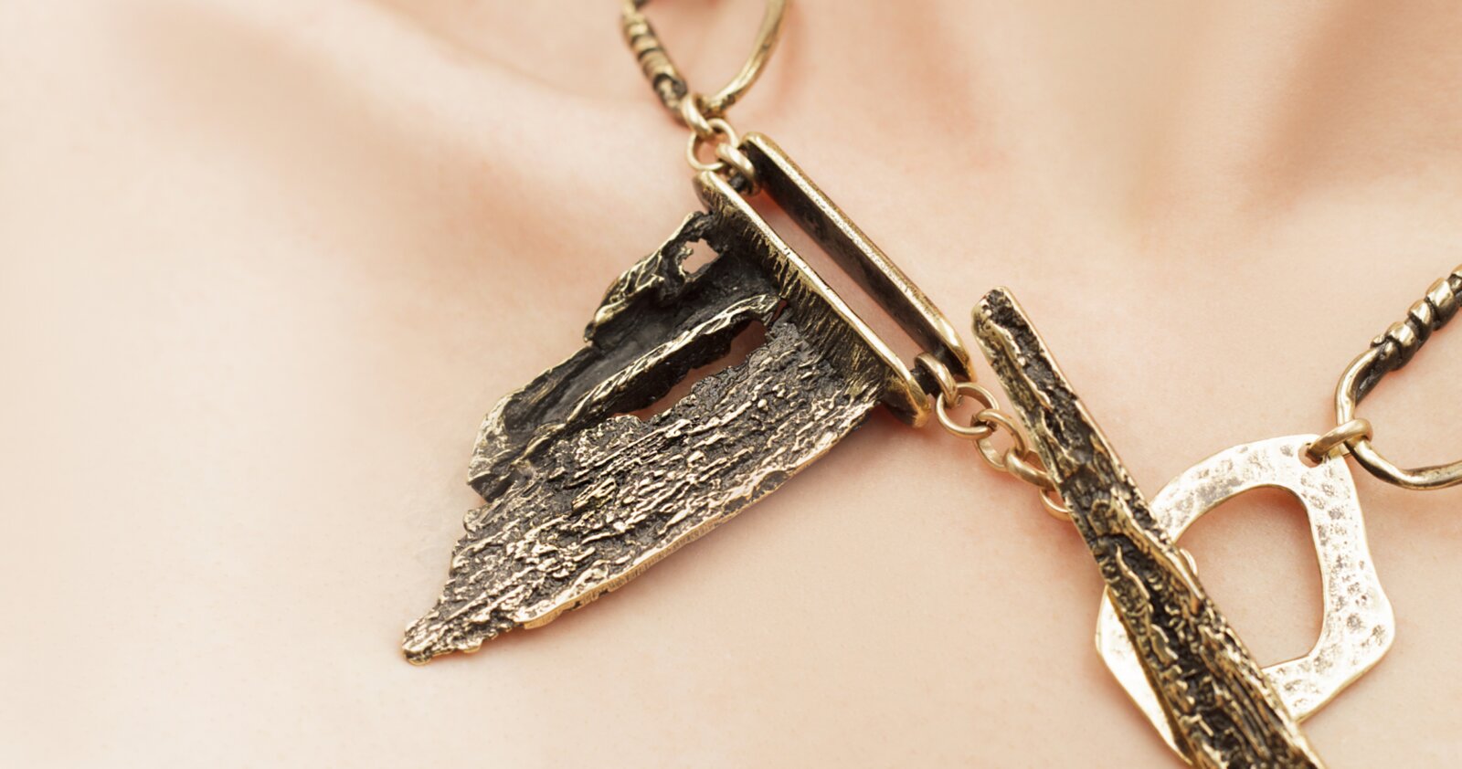 Handcrafted bronze and blackened gold necklace detail on skin